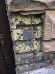 stone cladding over painted damaged brick