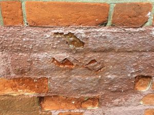 Eroding spalled bricks paint damage